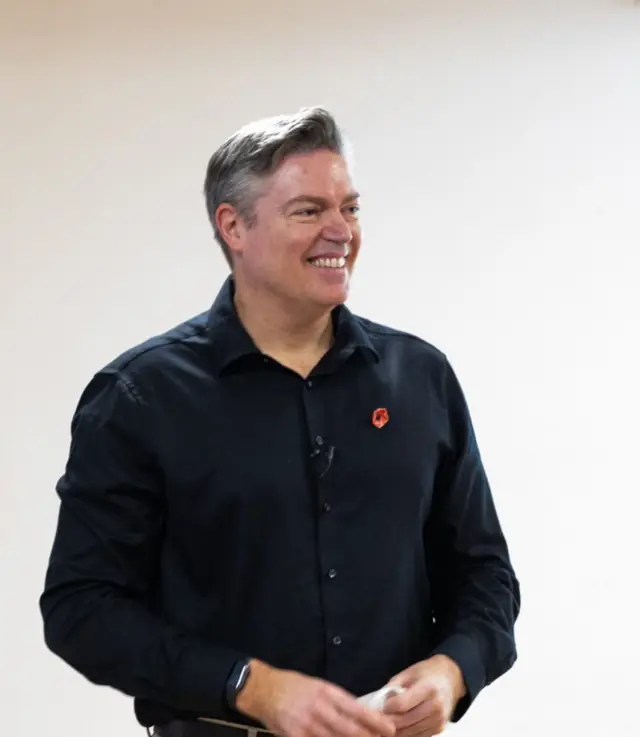 Ewan Norrie smiling while presenting a talk